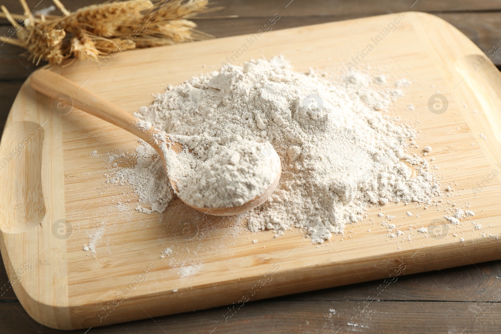 Pile of flour, spoon and spikes on wooden table, closeup Photo of Pile of flour, spoon and spikes on wooden table, closeup