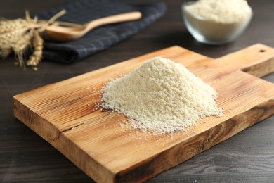 Photo of Pile of flour on dark wooden table, closeup