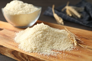 Photo of Pile of flour and spike on dark wooden table, closeup