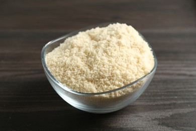 Photo of Flour in bowl on dark wooden table, closeup