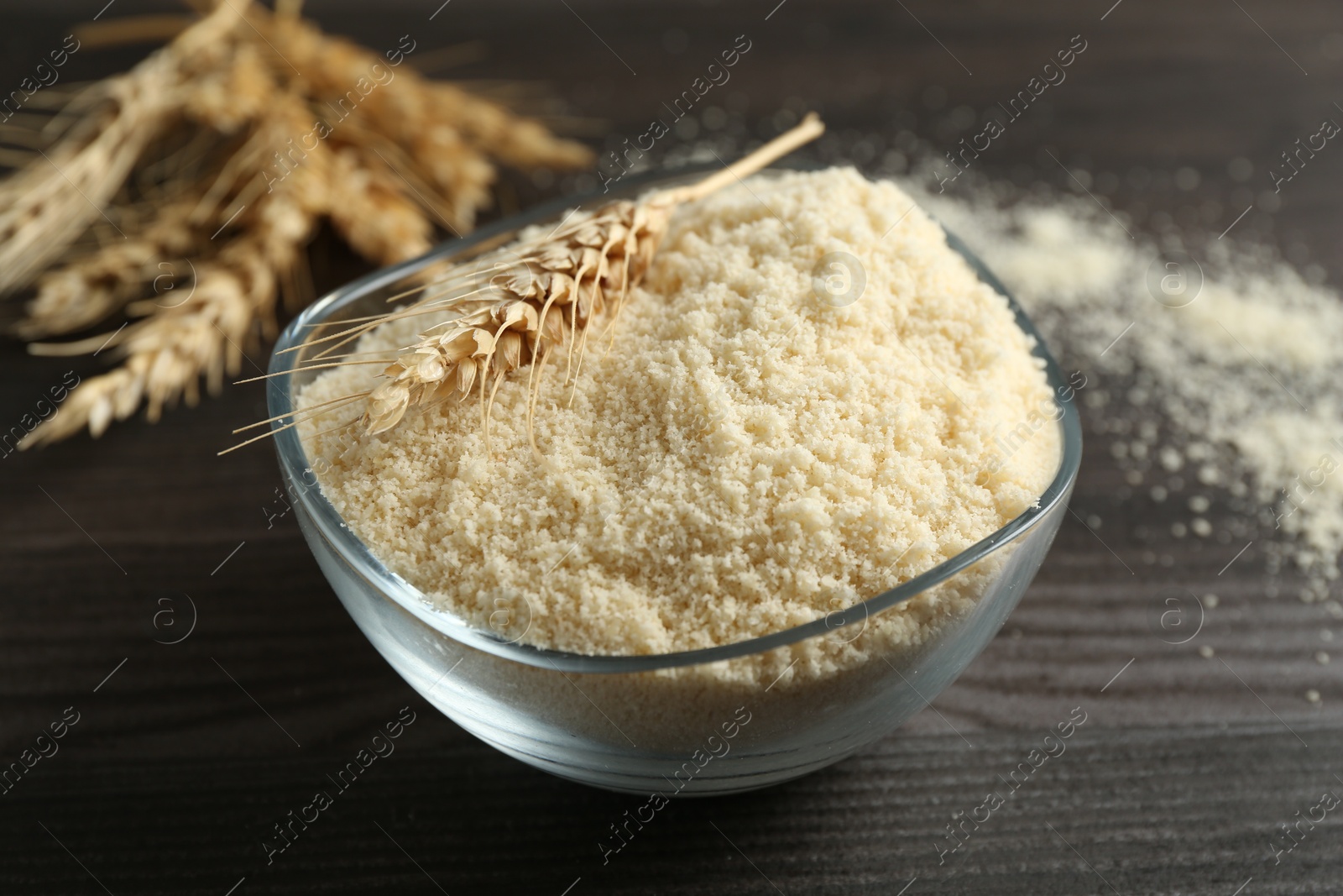 Flour and spike in bowl on dark wooden table, closeup Photo of Flour and spike in bowl on dark wooden table, closeup