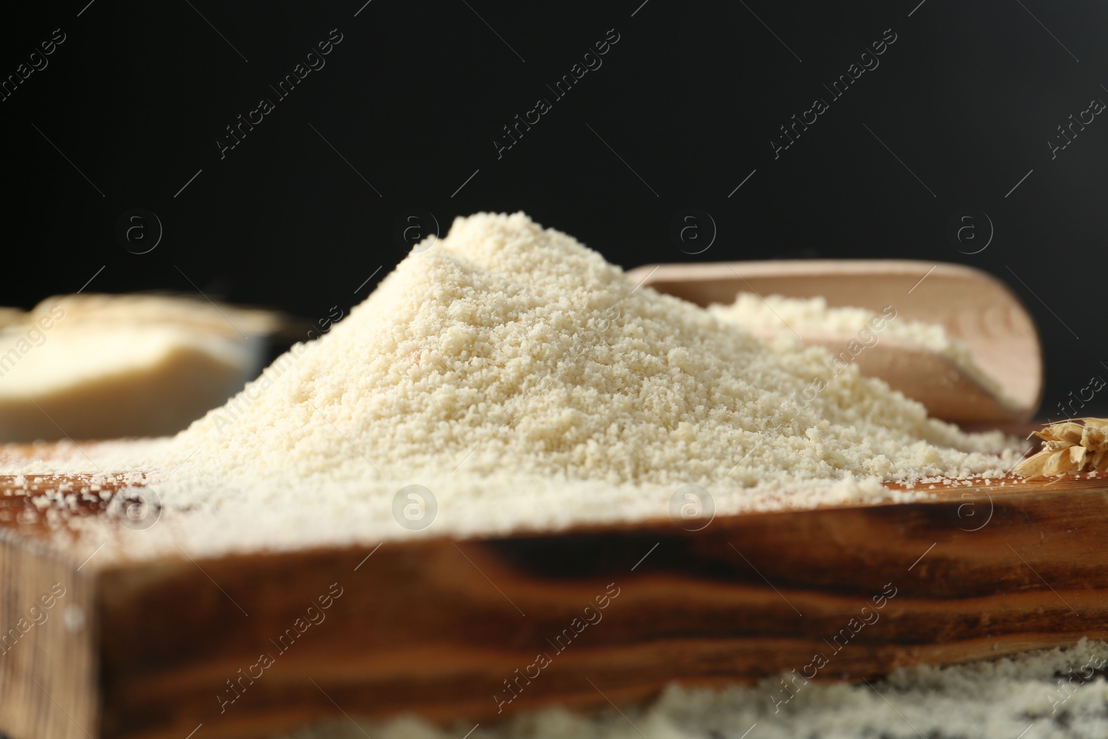 Pile of flour on wooden board against black background, closeup Photo of Pile of flour on wooden board against black background, closeup