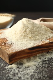 Photo of Pile of flour on dark table against black background, closeup