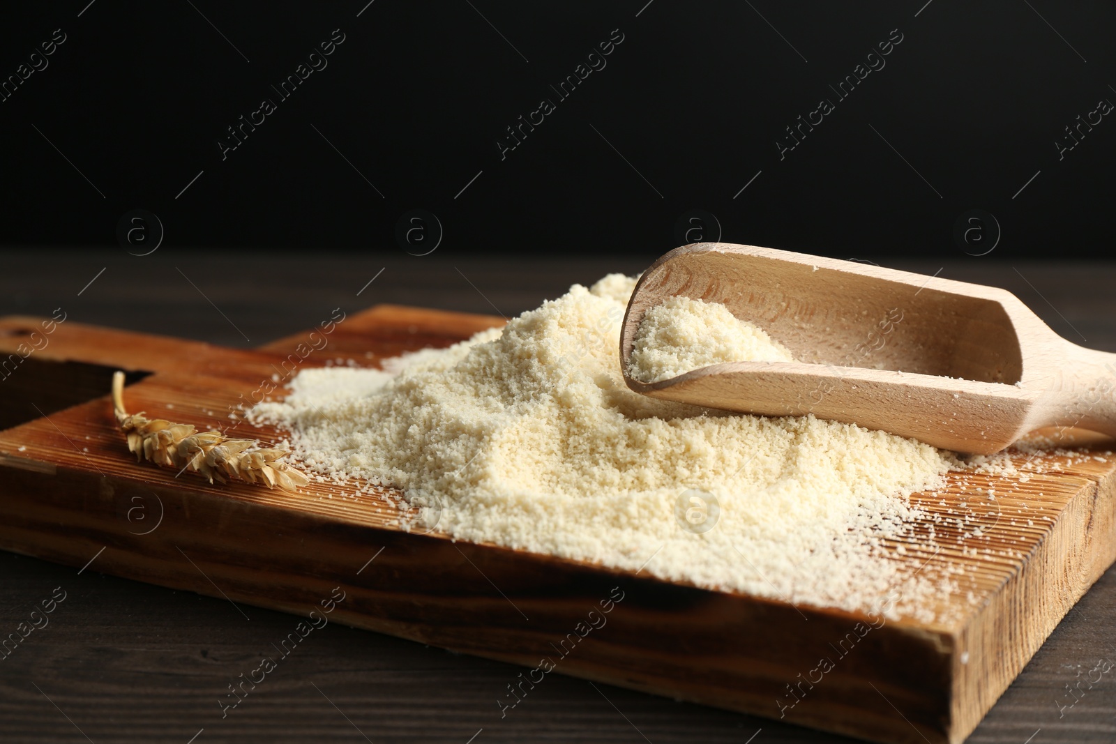 Pile of flour and scoop on dark wooden table against black background, closeup Photo of Pile of flour and scoop on dark wooden table against black background, closeup
