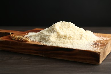 Photo of Pile of flour and spike on dark wooden table against black background, closeup