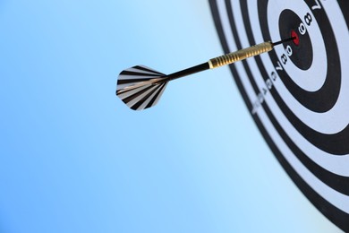 Photo of Targeting. Dart board with arrow against blue sky, closeup