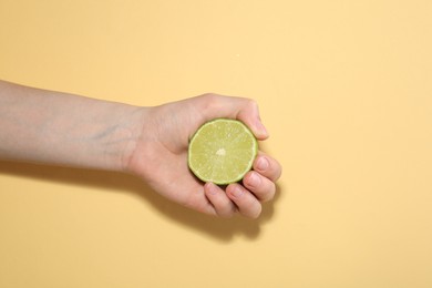 Photo of Woman with lime on yellow background, closeup