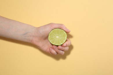 Photo of Woman with lime on yellow background, closeup