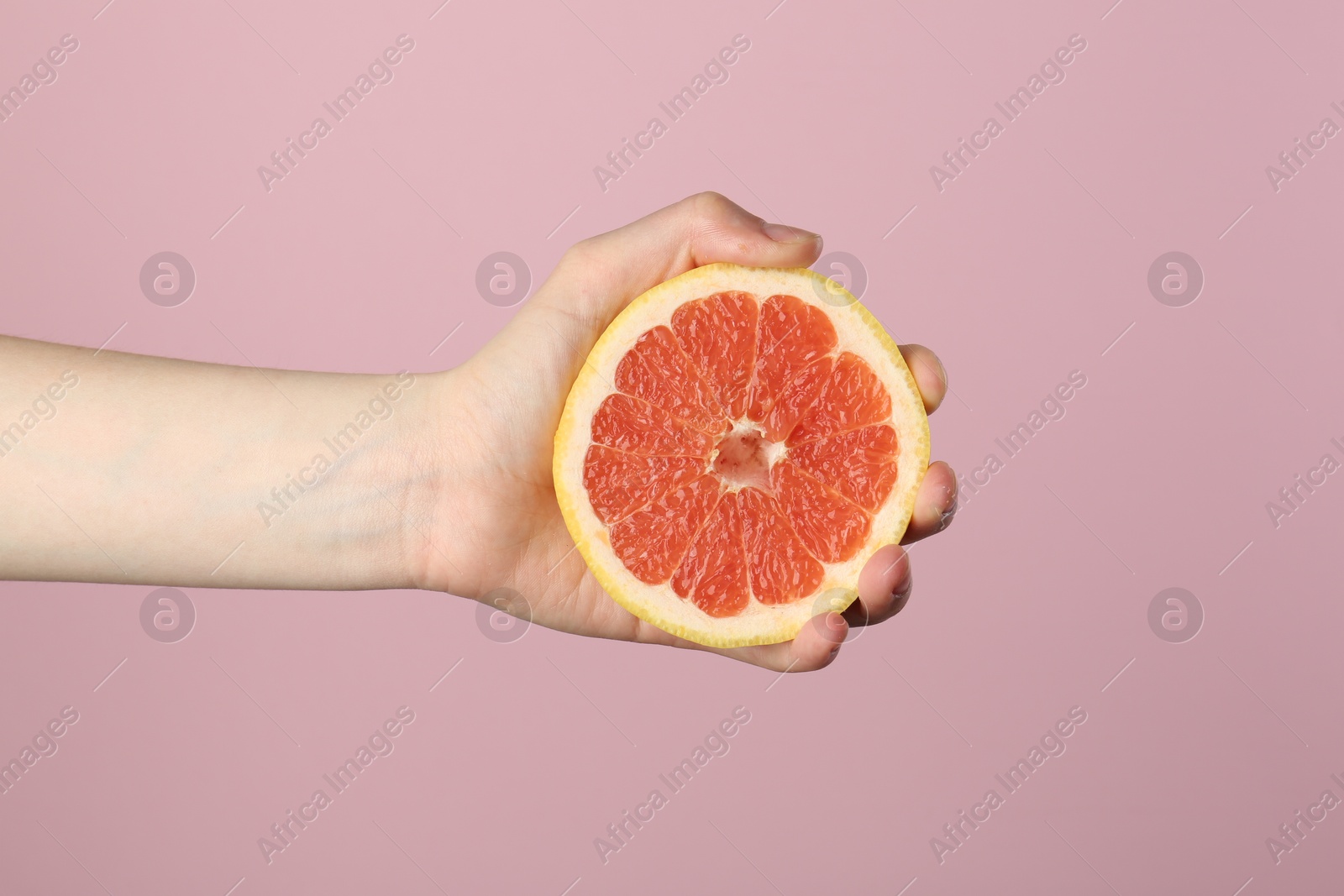 Woman with grapefruit on pink background, closeup Photo of Woman with grapefruit on pink background, closeup