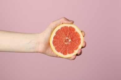Photo of Woman with grapefruit on pink background, closeup