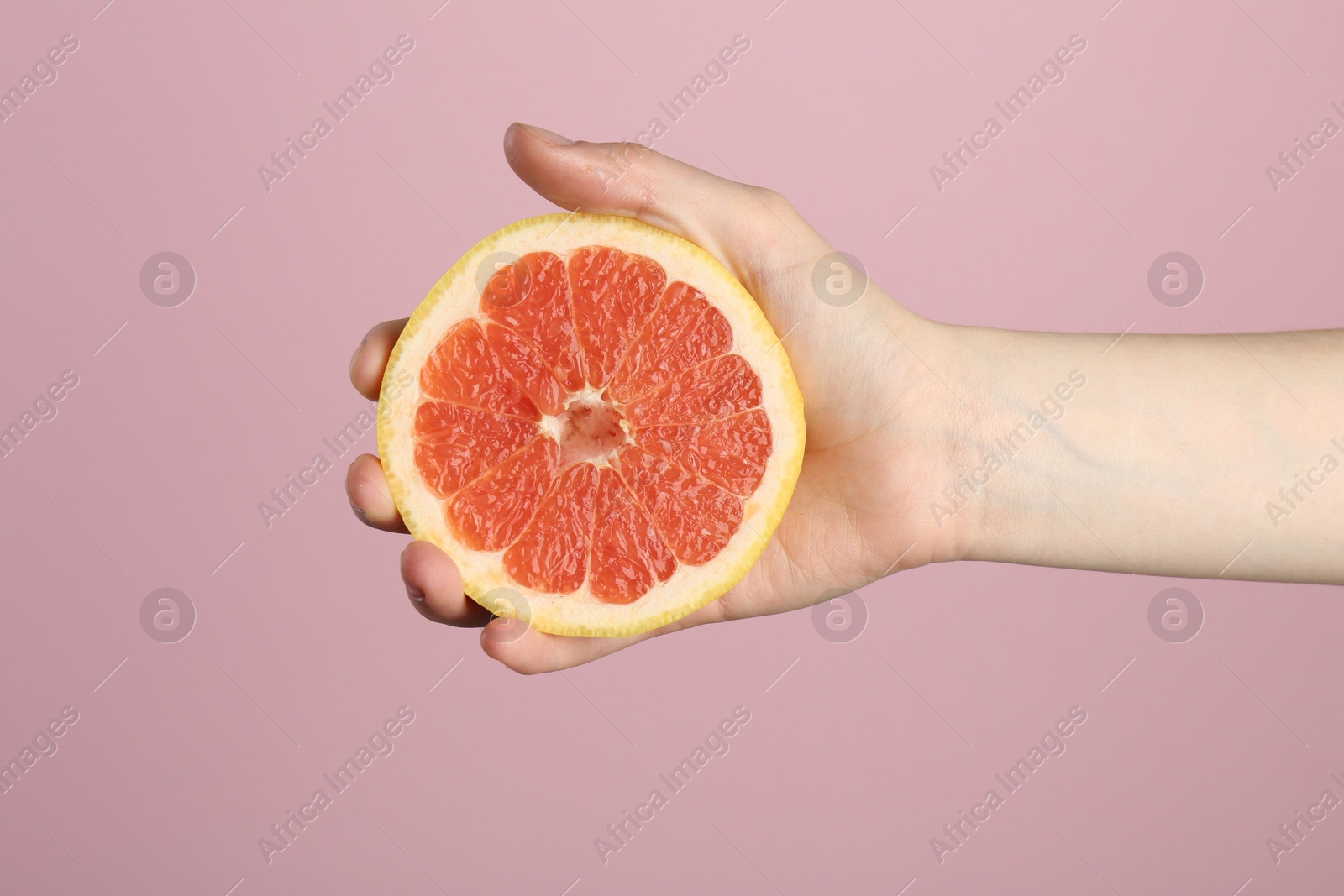 Woman with grapefruit on pink background, closeup Photo of Woman with grapefruit on pink background, closeup