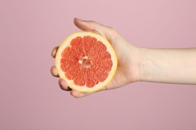 Photo of Woman with grapefruit on pink background, closeup