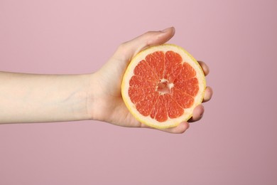 Photo of Woman with grapefruit on pink background, closeup