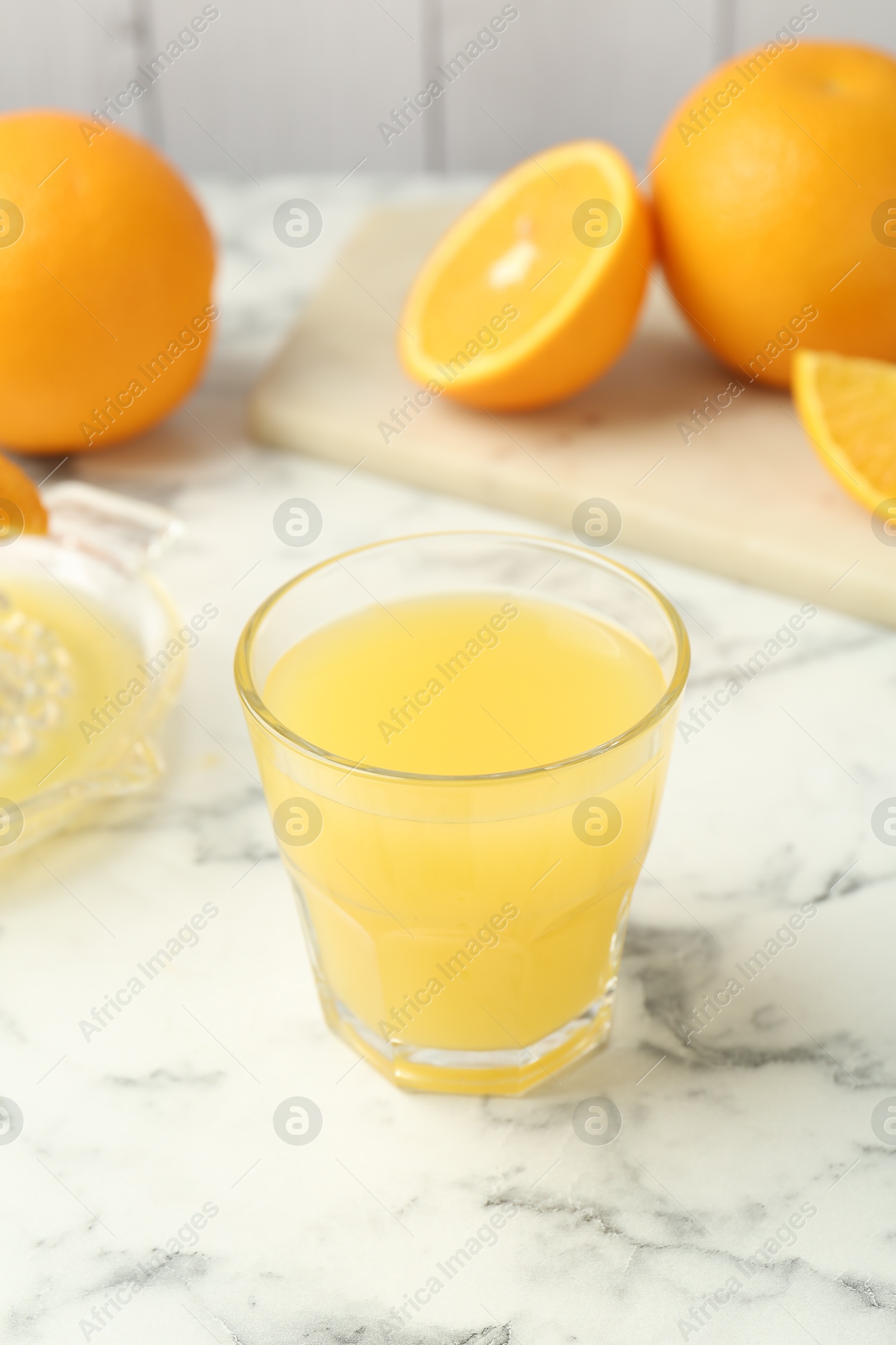 Fresh orange juice and fruits on white marble table, closeup Photo of Fresh orange juice and fruits on white marble table, closeup