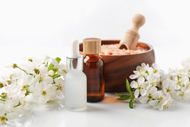 Photo of Spa composition with cosmetic products and beautiful flowers on white background, closeup