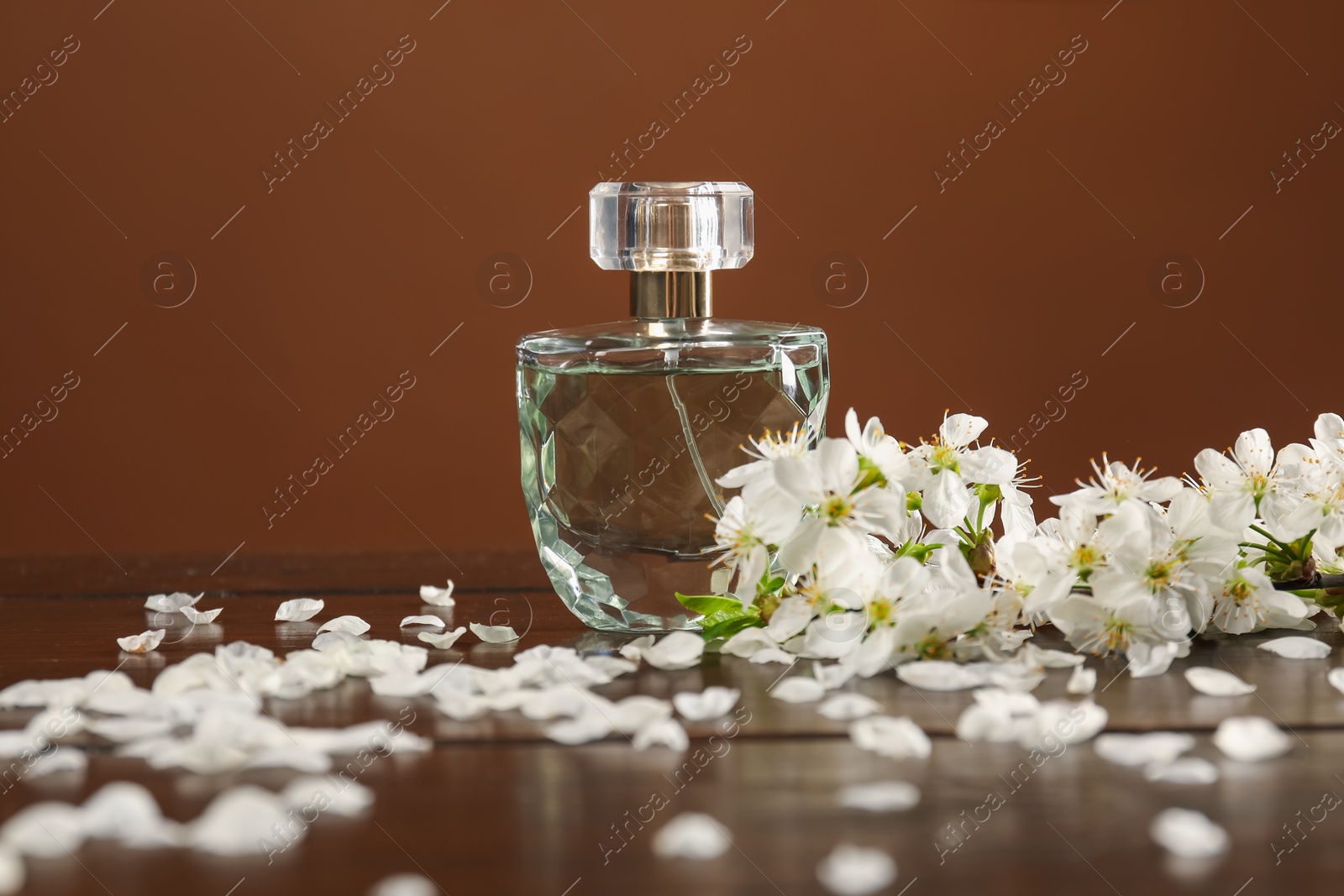 Aromatic perfume and beautiful flowers on wooden table, closeup Photo of Aromatic perfume and beautiful flowers on wooden table, closeup