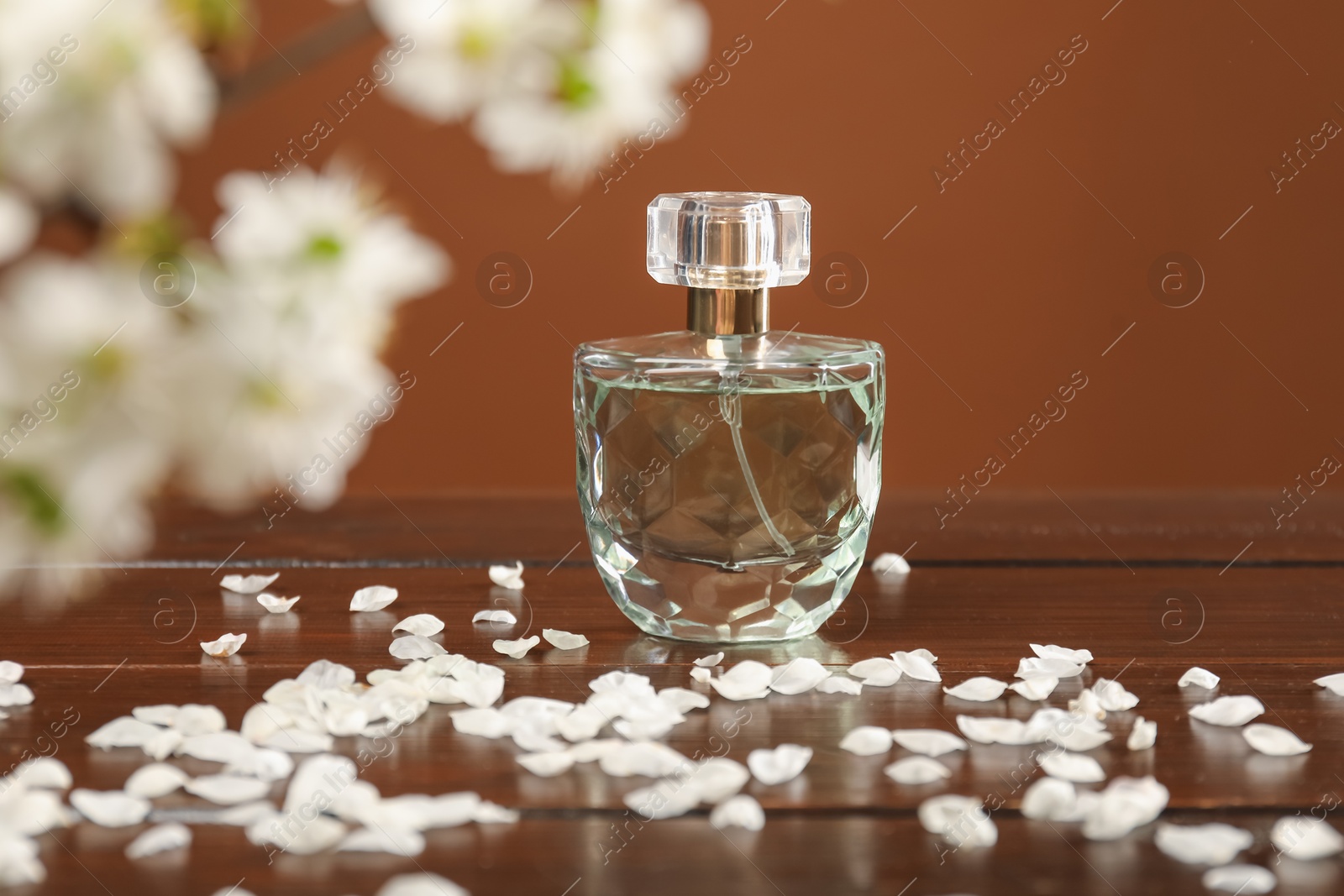 Aromatic perfume and beautiful flowers on wooden table, closeup Photo of Aromatic perfume and beautiful flowers on wooden table, closeup