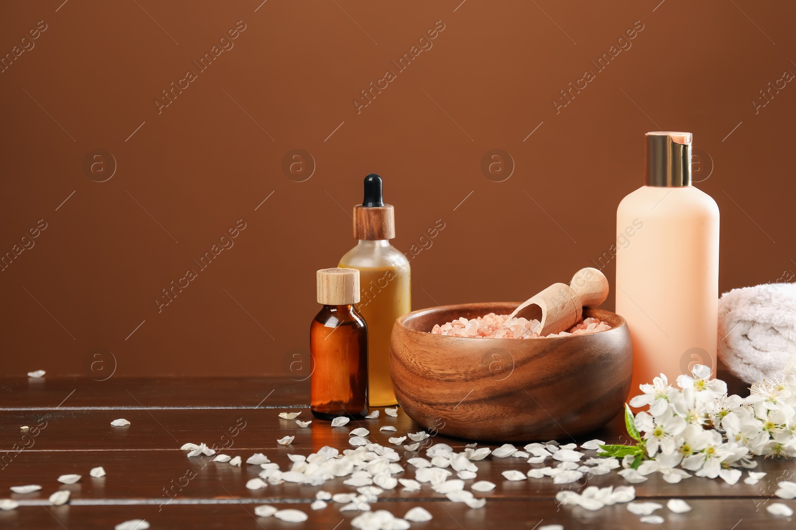 Spa composition with cosmetic products and beautiful flowers on wooden table, closeup. Space for text Photo of Spa composition with cosmetic products and beautiful flowers on wooden table, closeup. Space for text