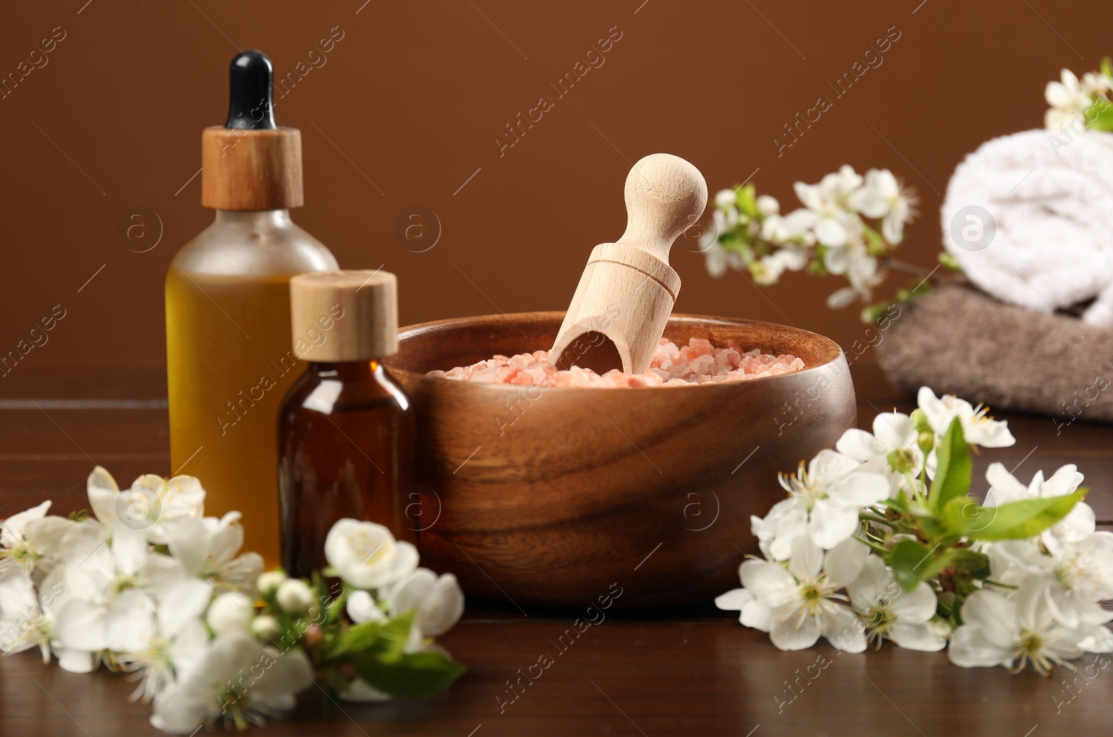 Spa composition with cosmetic products and beautiful flowers on wooden table, closeup Photo of Spa composition with cosmetic products and beautiful flowers on wooden table, closeup
