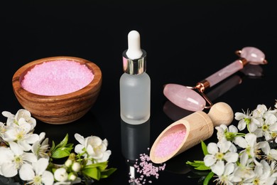 Photo of Spa composition with cosmetic products and beautiful flowers on black mirror surface, closeup
