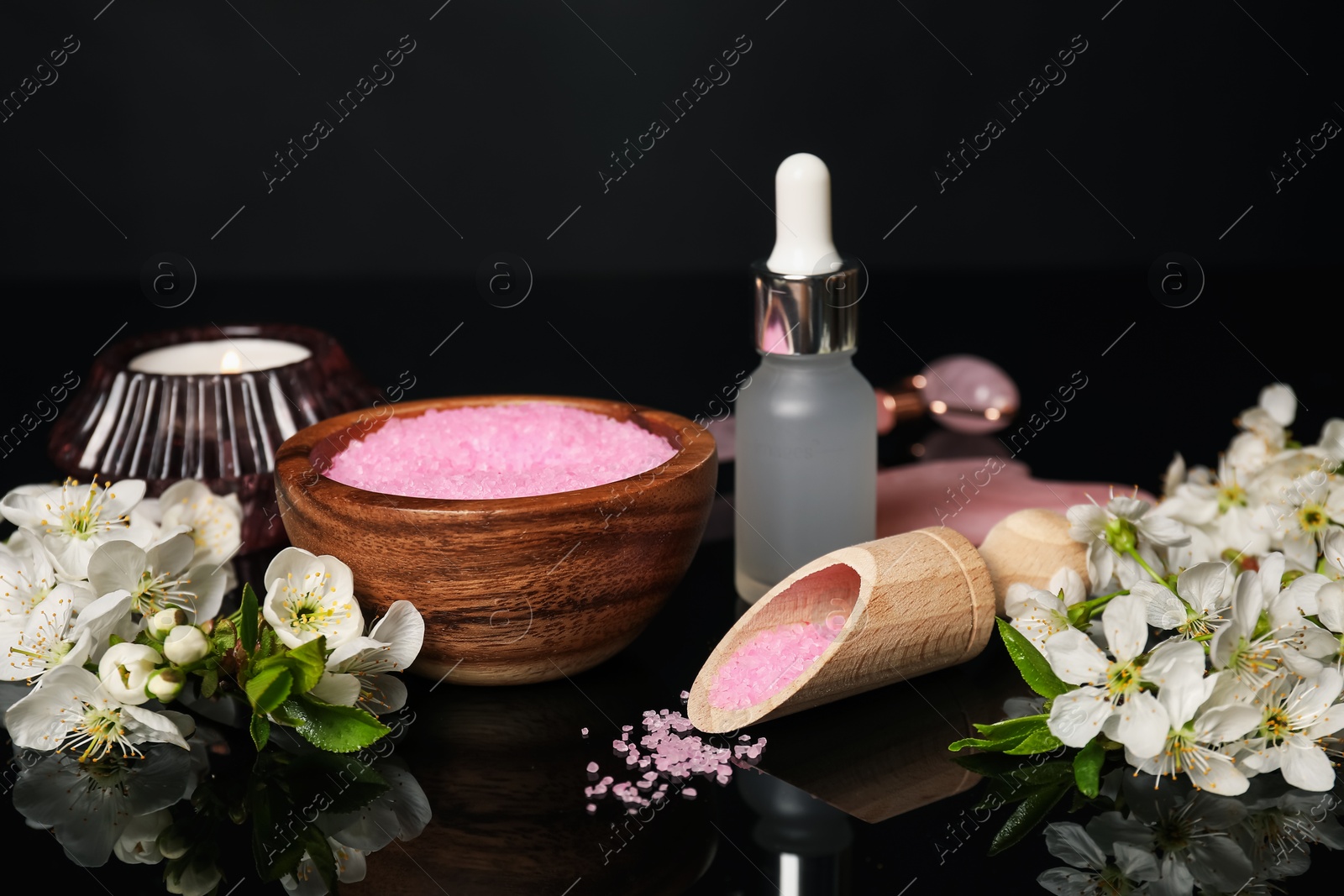 Spa composition with cosmetic products, burning candle and beautiful flowers on black mirror surface, closeup Photo of Spa composition with cosmetic products, burning candle and beautiful flowers on black mirror surface, closeup