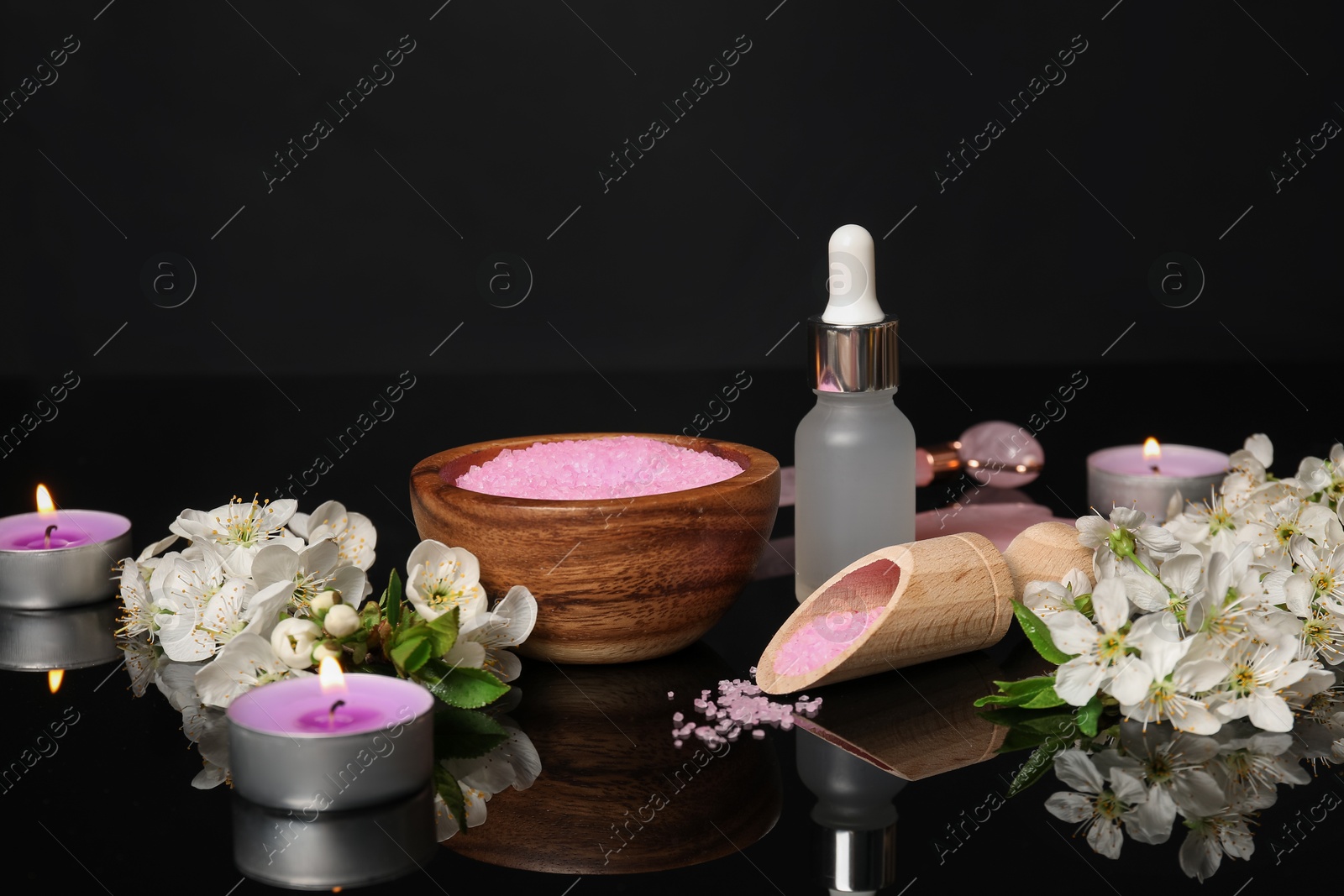 Spa composition with cosmetic products, burning candles and beautiful flowers on black mirror surface, closeup Photo of Spa composition with cosmetic products, burning candles and beautiful flowers on black mirror surface, closeup