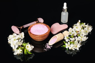 Photo of Spa composition with cosmetic products and beautiful flowers on black mirror surface