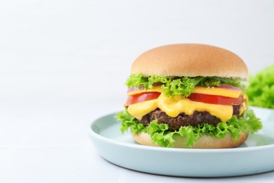 Photo of Tasty cheeseburger on white table, closeup. Space for text