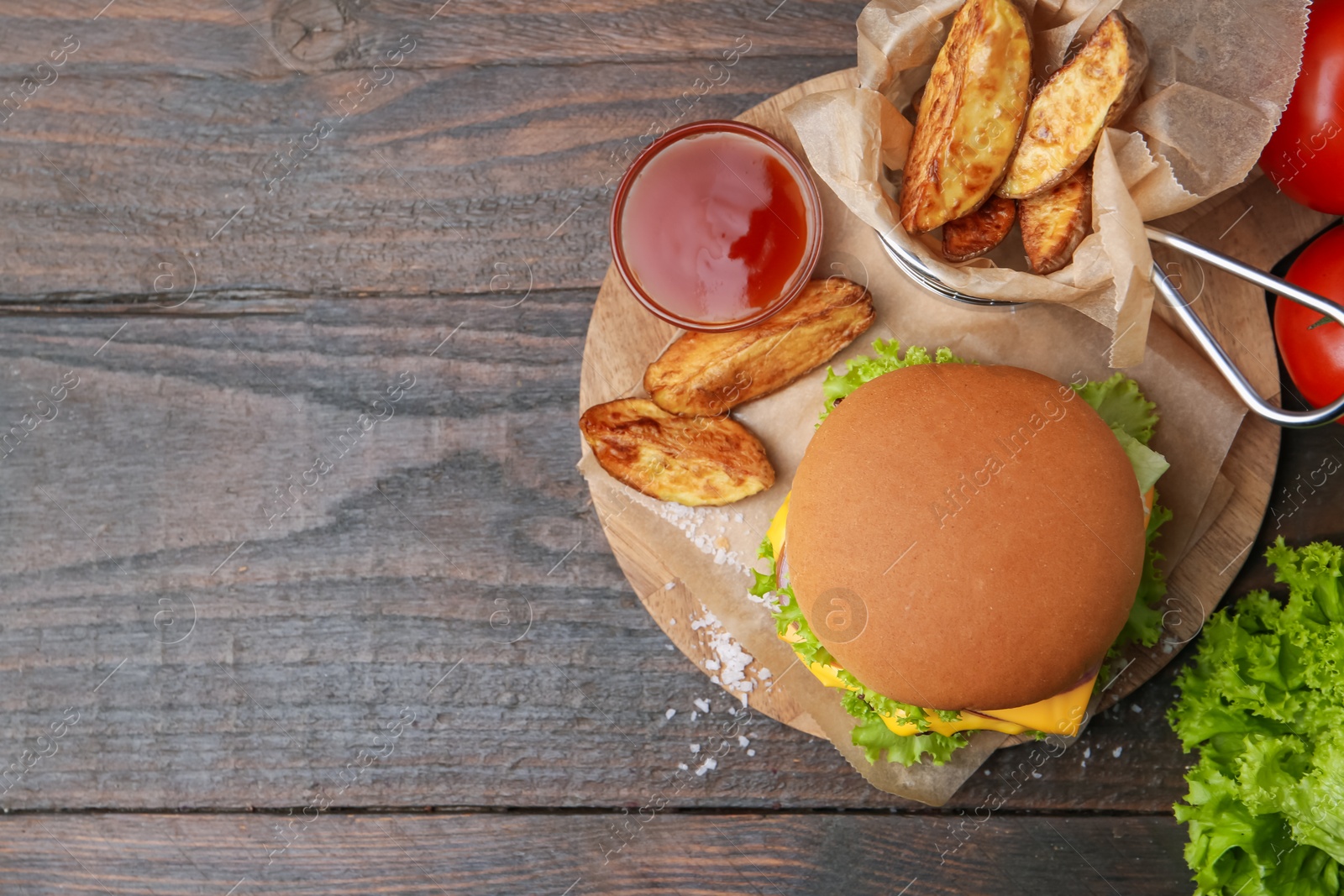 Tasty cheeseburger with potato wedges and ketchup on wooden table, flat lay. Space for text Photo of Tasty cheeseburger with potato wedges and ketchup on wooden table, flat lay. Space for text