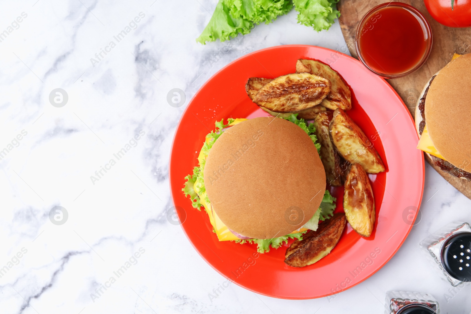 Tasty cheeseburger with potato wedges and ketchup on white marble table, flat lay. Space for text Photo of Tasty cheeseburger with potato wedges and ketchup on white marble table, flat lay. Space for text