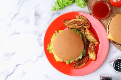 Photo of Tasty cheeseburger with potato wedges and ketchup on white marble table, flat lay. Space for text