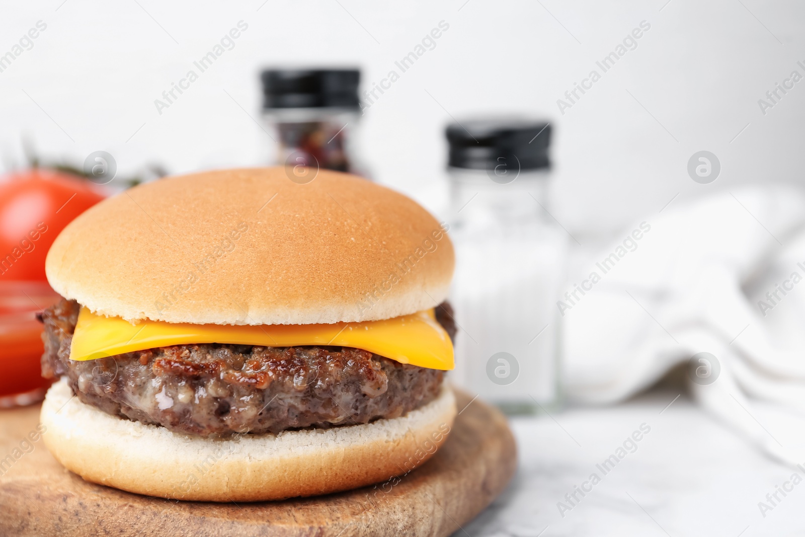 Tasty cheeseburger on white marble table, closeup. Space for text Photo of Tasty cheeseburger on white marble table, closeup. Space for text