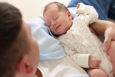 Photo of Father with his cute newborn baby indoors, above view