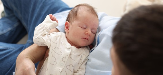 Photo of Father with his cute newborn baby indoors, above view