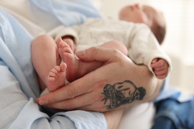 Photo of Father with his cute newborn baby indoors, closeup