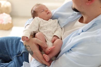 Photo of Father with his cute newborn baby indoors, closeup