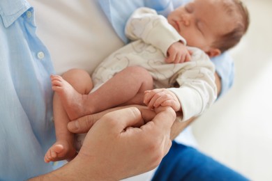 Photo of Father with his cute newborn baby indoors, closeup