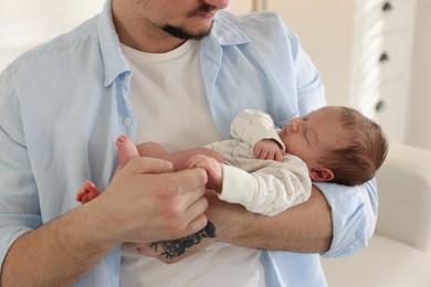 Photo of Father with his cute newborn baby indoors, closeup