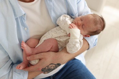 Photo of Father with his cute newborn baby indoors, closeup