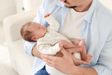 Photo of Father with his cute newborn baby indoors, closeup