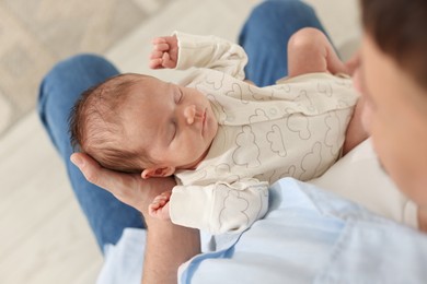 Photo of Father with his cute newborn baby indoors, above view