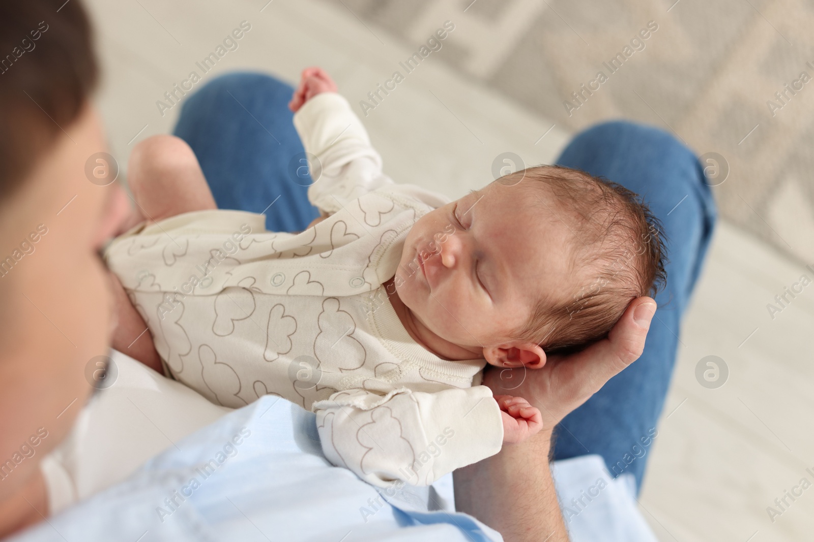 Photo of Father with his cute newborn baby indoors, above view