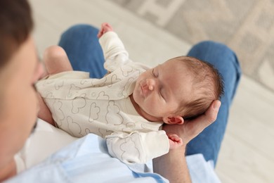 Photo of Father with his cute newborn baby indoors, above view
