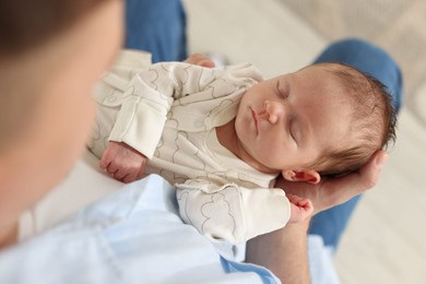 Photo of Father with his cute newborn baby indoors, above view