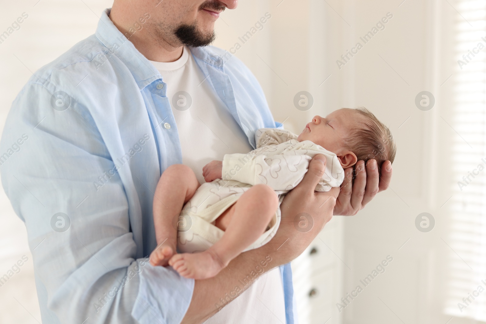 Father with his cute newborn baby indoors, closeup Photo of Father with his cute newborn baby indoors, closeup
