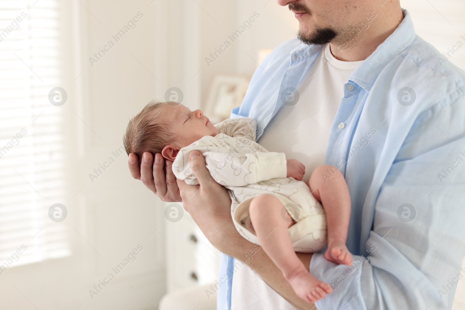 Father with his cute newborn baby indoors, closeup. Space for text Photo of Father with his cute newborn baby indoors, closeup. Space for text