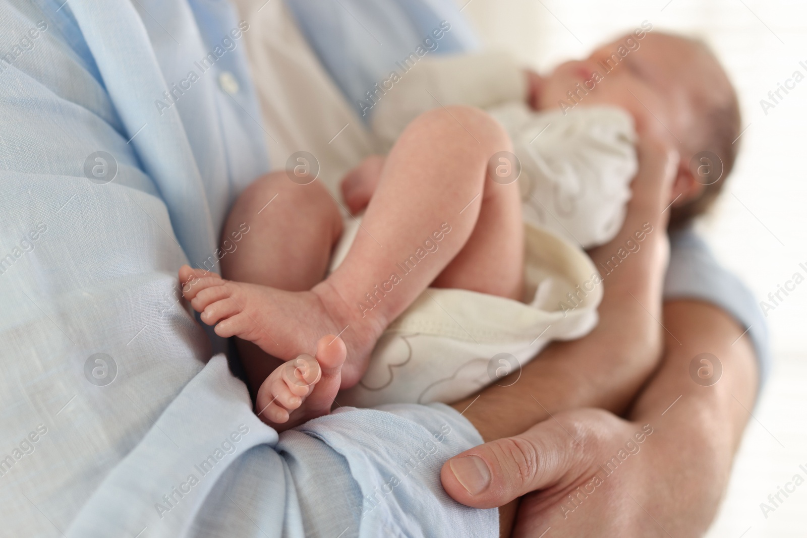 Father with his cute newborn baby indoors, closeup Photo of Father with his cute newborn baby indoors, closeup
