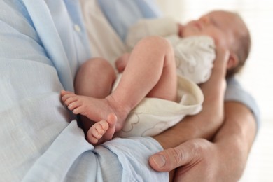 Photo of Father with his cute newborn baby indoors, closeup