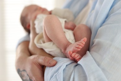 Photo of Father with his cute newborn baby indoors, closeup