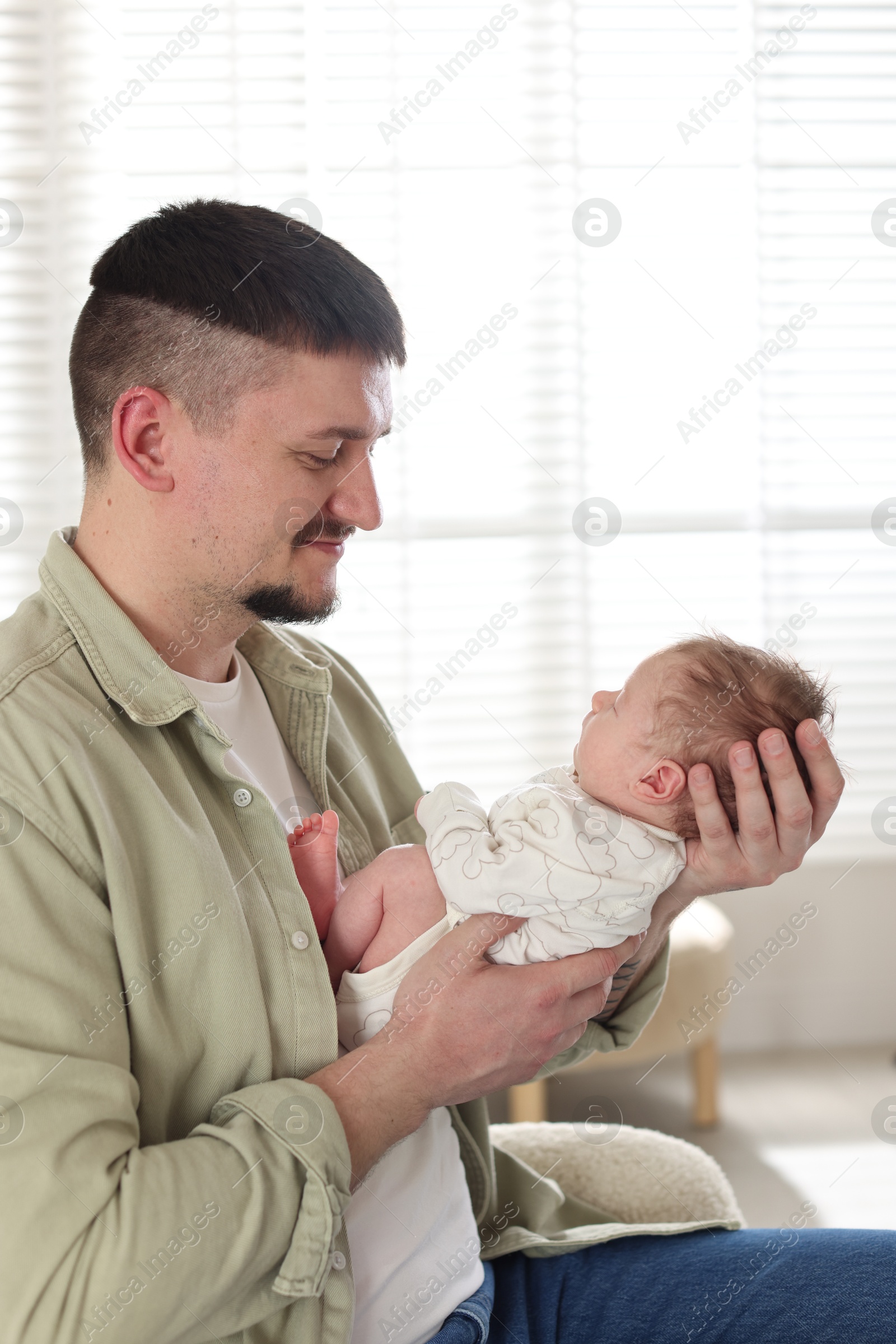 Father with his cute newborn baby indoors Photo of Father with his cute newborn baby indoors